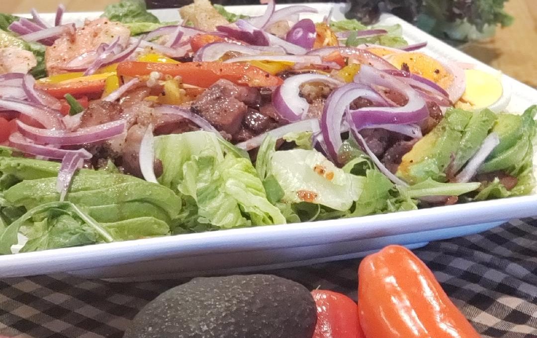 A summer harvest salad with vegetables beside it