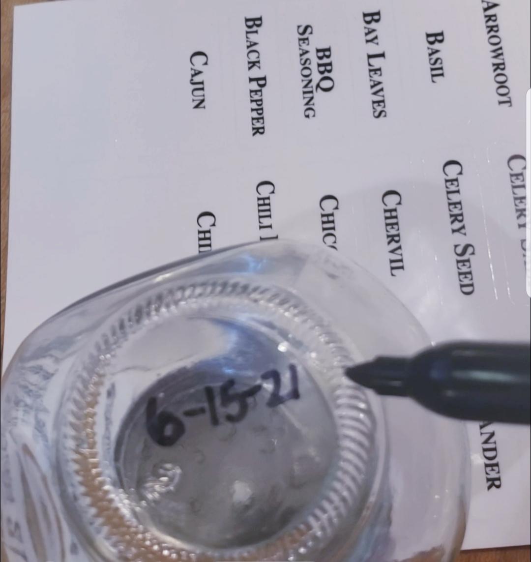 writing of expiration date of spices on bottom of jar